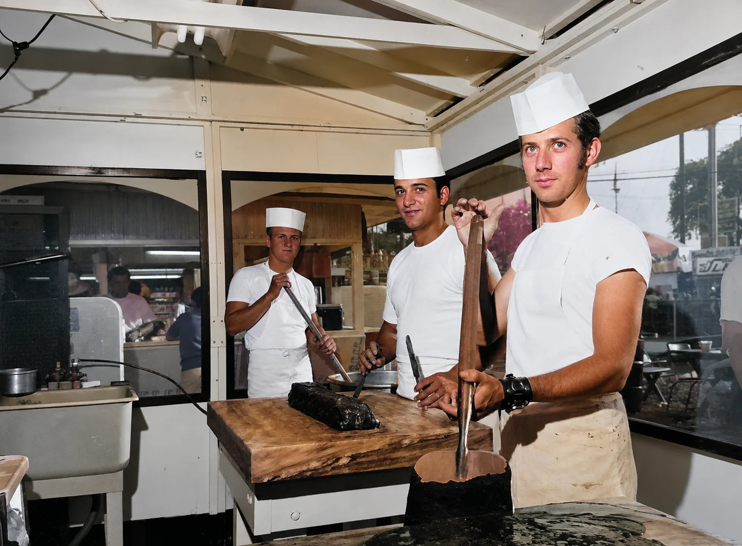 Three early fudge makers working inside a fudge shop